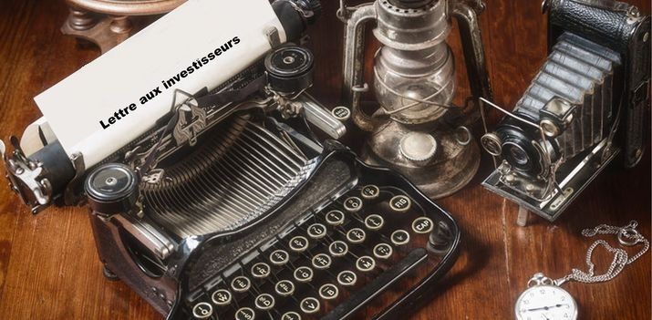 Une machine à écrire ancienne, une feuille titrée « Lettre aux investisseurs », une montre à gousset et un appareil photo d'époque