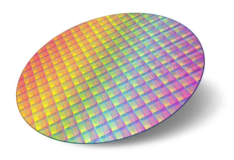 Une plaque de silicium (wafer) couverte de puces aux reflets irisés